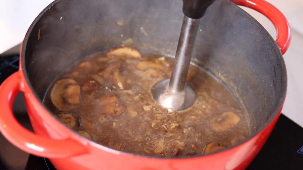 mushroom soup in the pot with immersion blender