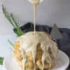 roasted cauliflower on a plate with tahini sauce pouring on top