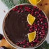 chocolate tart seen from above, topped with pomegranate and orange slices