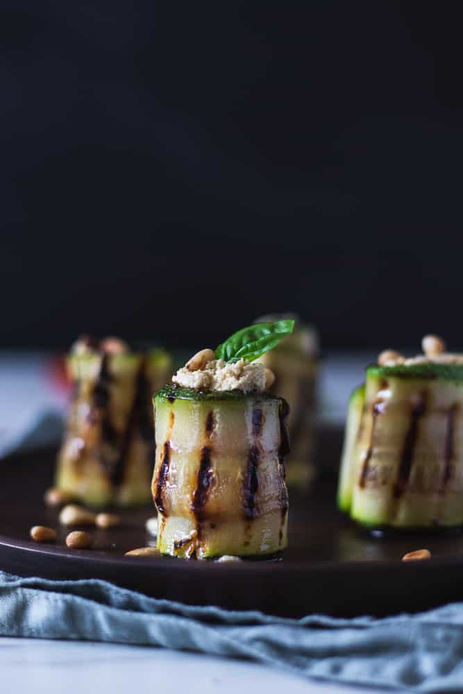 grilled zucchini rolls in a plate filled with tofu ricotta