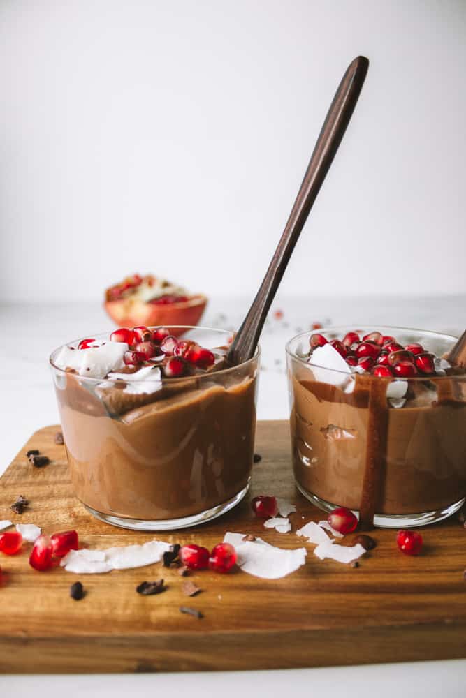 sweet potato chocolate mousse in 2 glasses with pomegranate and coconut flakes