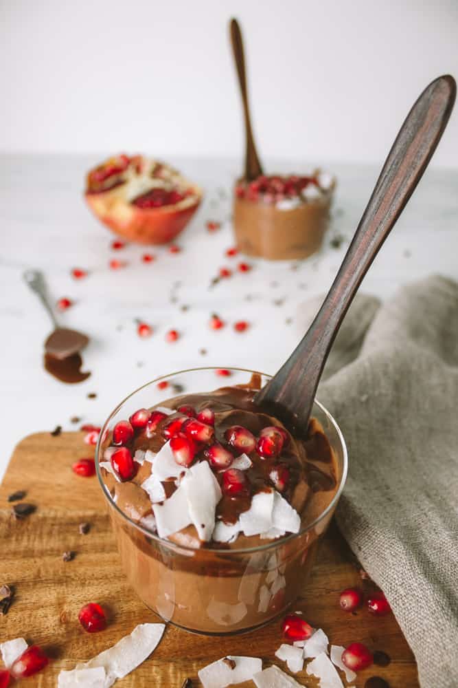 sweet potato chocolate mousse in 2 glasses with pomegranate and coconut flakes
